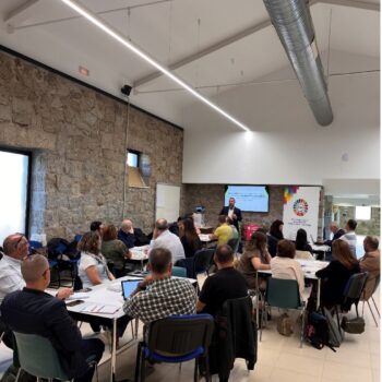 Representantes de distintas administraciones participan en una dinámica de trabajo en equipo dentro de una sala de reuniones.