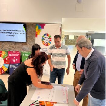 Representantes de distintas administraciones participan en una dinámica de trabajo en equipo dentro de una sala de reuniones.