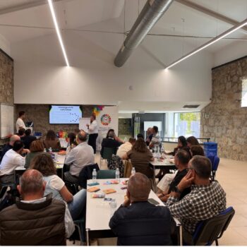 Representantes de distintas administraciones participan en una dinámica de trabajo en equipo dentro de una sala de reuniones.
