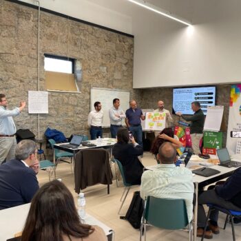 Representantes de distintas administraciones participan en una dinámica de trabajo en equipo dentro de una sala de reuniones.