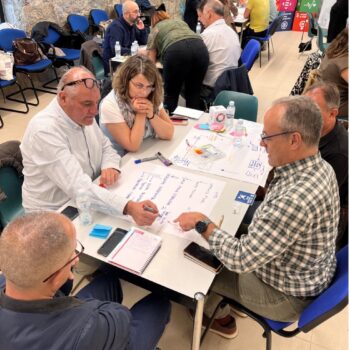 Representantes de distintas administraciones participan en una dinámica de trabajo en equipo dentro de una sala de reuniones.