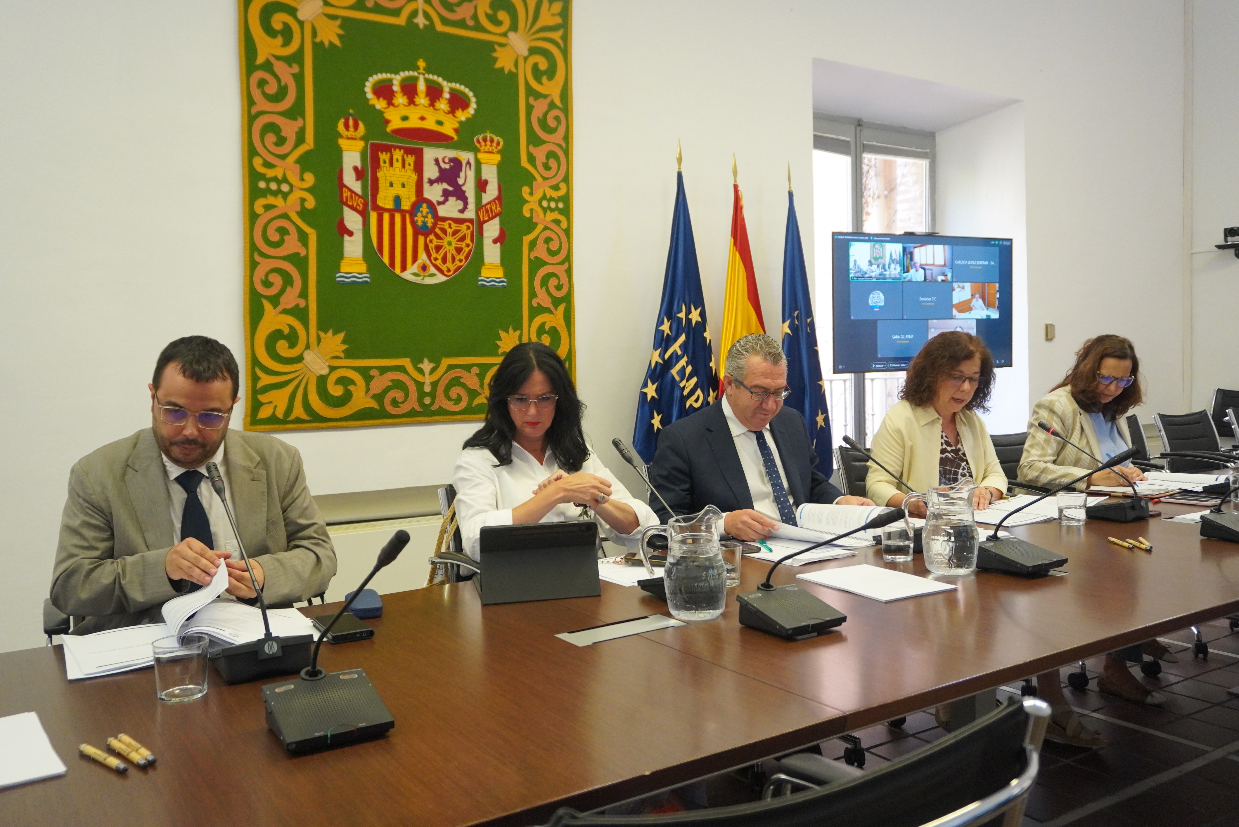 Celebración de un acto institucional con diferentes personas en torno a una mesa.